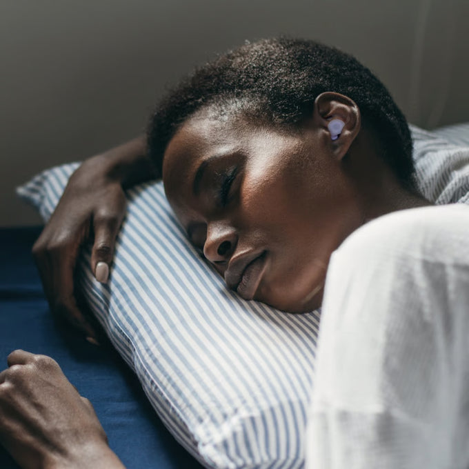 Woman sleeping with Loop Dream lilac earplugs in ears