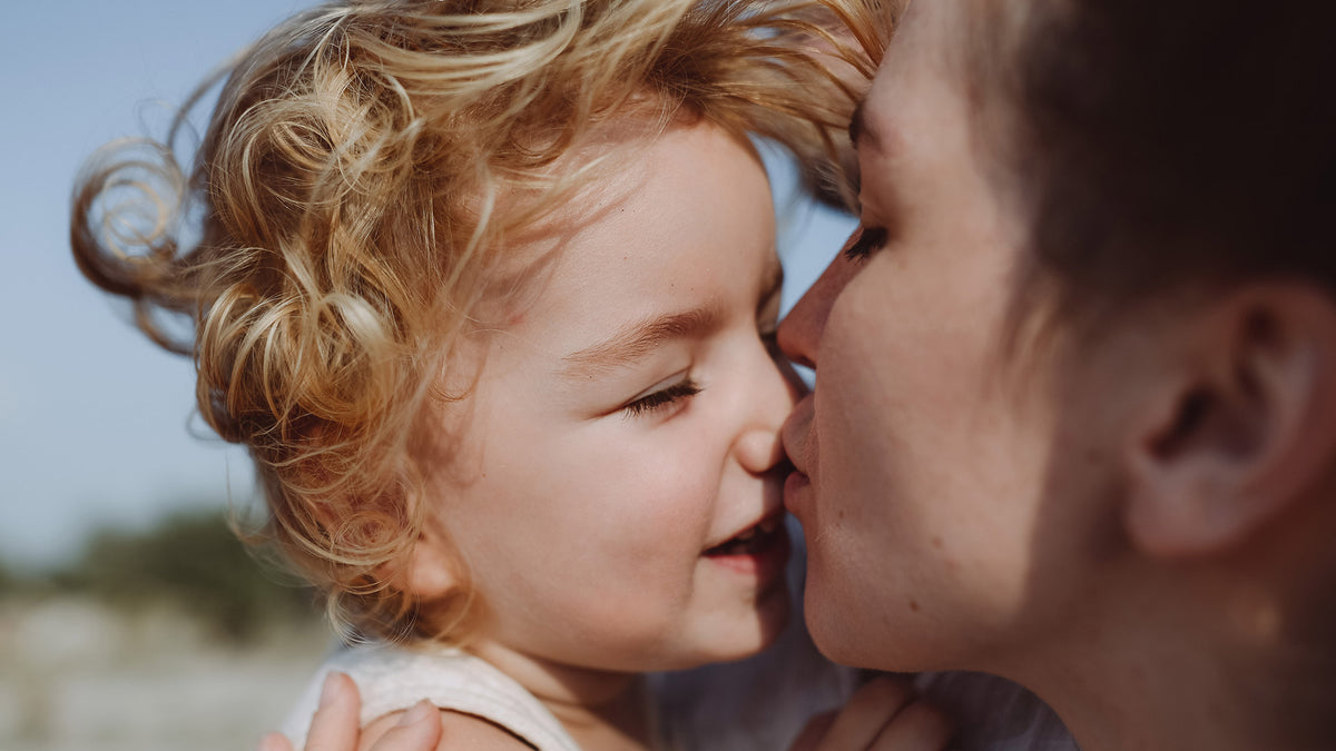Mother kissing child 